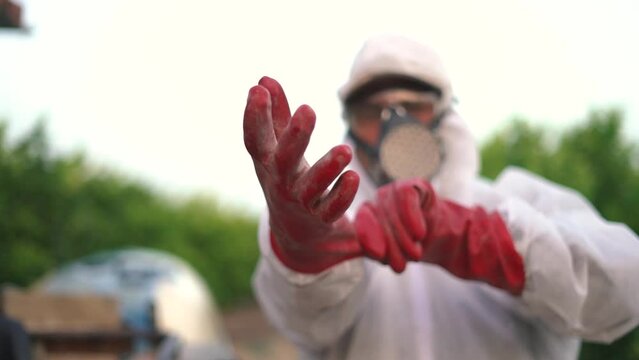 Farmer wearing protective gloves while spraying pesticide on lemon trees with tractor