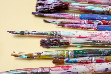 Obraz premium Dirty paint brushes on beige background