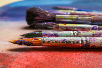 Fototapeta premium Dirty paint brushes on colorful background
