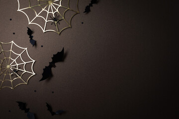Halloween party decorations at night from bats, spider web and confetti top view. Happy halloween minimal holiday greeting card on dark background flat lay..