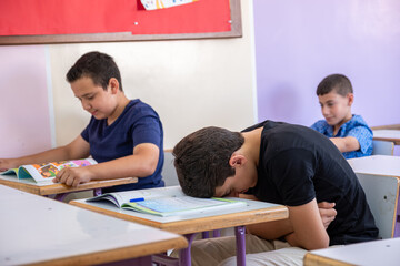 Student putting his head on the desk ,looks not feeling well or sleeping