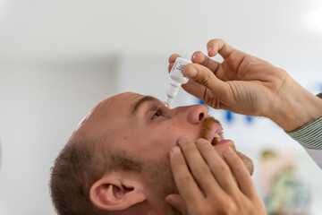 Man drops eye drops install lenses, moisturizing. Preservation and solution vision problems. Eye diseases are recognized. Drops before putting on lenses or before removing at end day