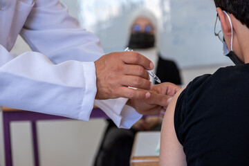 Doctor providing vaccine to the students in the classroom