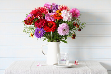 A bouquet of garden flowers on a table on a white background. High key.