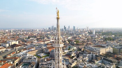Europe, Italy, Milan - Aerial view of Piazza Duomo, gothic Cathedral in downtown center city. Drone aerial view of Madonnina statue   and rooftops and new skyline  - Duomo Unesco Heritage sightseeing 