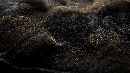 Black glitter with gold flecks. Golden loosened sand on ground.