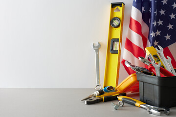 Applaud the unwavering commitment of construction workers this Labor Day. Side view of american flag, tools box organizer on white background with empty space for promo or text