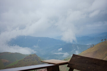 Fototapeta premium The stunning view from a tourist's standpoint as they go down a hill on a foggy trail in Nan, Thailand.