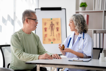 Female doctor showing bottle of pills to explaining medicine use and having consult healthcare to senior