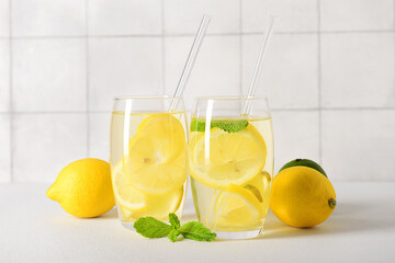 Glasses of tasty lemonade with mint on white table