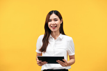 Fototapeta premium Young asian woman wearing white short sleeve shirt and holding tablet to working while standing to smiling
