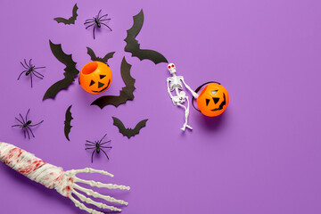 Composition with skeleton, hand, pumpkins, paper bats and spiders for Halloween celebration on purple background