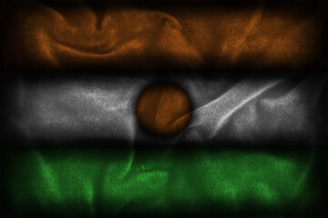 Nigerien flag illustration (representing the colors of Niger - Orange White Green) with dark textured fabric background