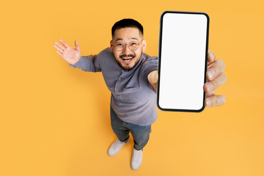 Great Promo. Excited Asian Man Showing Blank Smartphone With White Screen