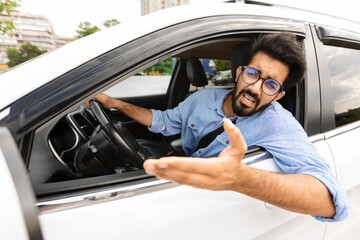 Angry driver stuck in traffic jam gesturing with hand, screaming