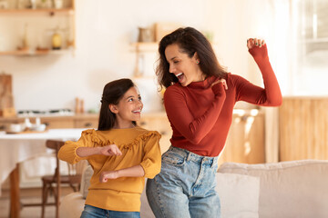 Cheerful Middle Eastern Mother And Daughter Kid Dancing At Home