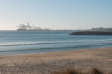 Landscape of Sao Torpes beach, Sines, Portugal at sunset. Sines harbor in background