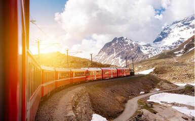 Red train moving in beautiful mountain landscape in Switzerland