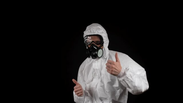 A man dances in a chemical protection suit with a respirator and goggles