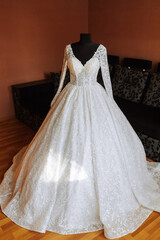 Fototapeta na wymiar white wedding dress with long train in room with home interior