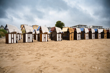 Roofed wicker beach chairs at the baltic sea beach, coast at the island of Usedom in Germany, storm...