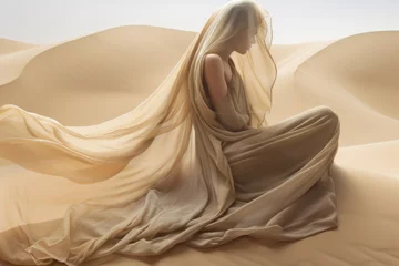 Gordijnen Woman in a long  dress sitting in the desert with flowing fabric in the wind © Jasmina