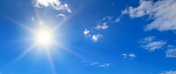 Naklejka na ściany i meble Sun, blue sky and light clouds. Wide photo.