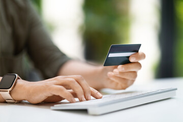 Woman hands holding credit card and using computer