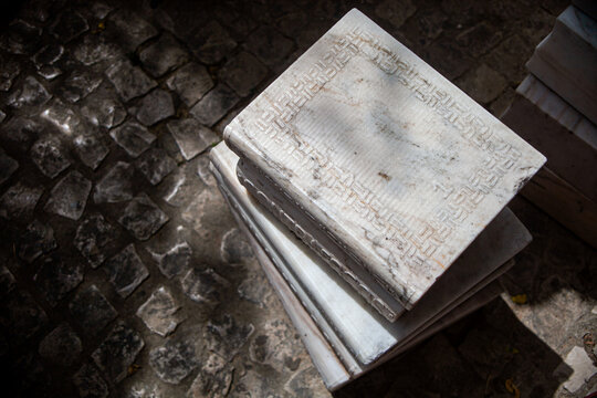 Melides, Alentejo, Portugal. June 18 of 2023. Sculpted marble books stacked artfully, a unique masterpiece gracing Melides village center. A blend of literature and craftsmanship