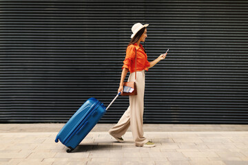 Joyful Passenger Woman Using Mobile Phone to Book Tickets Outside © Prostock-studio