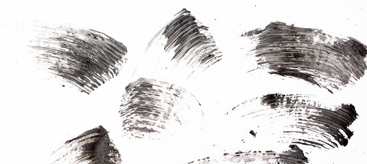 Black mascara brush strokes isolated on white.