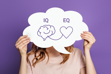 iq eq concept. girl holding white poster with hand drawing a brain and heart - obrazy, fototapety, plakaty