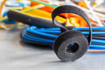 Roll of hook and loop velcro tape used to organize cable in electrical and telecommunications installations