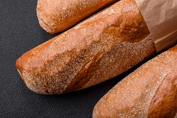 French baguette bread on a dark textured concrete background