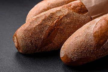 French baguette bread on a dark textured concrete background