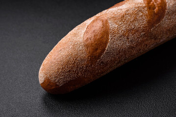 French baguette bread on a dark textured concrete background