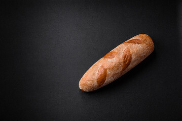 French baguette bread on a dark textured concrete background