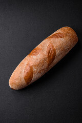 French baguette bread on a dark textured concrete background