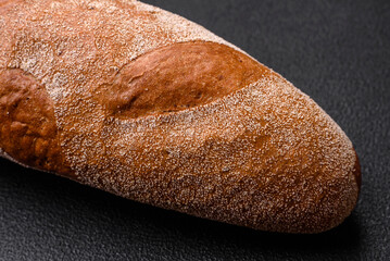 French baguette bread on a dark textured concrete background