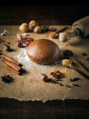 An arrangement of gingerbread pastry, natural ingredients and baking utensils on an old wooden table
