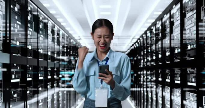 Asian Woman Celebrating Succeed Using Smartphone Managing Supercomputer Network In Server Room Database
