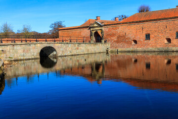 Brick stone bridge across the lake surrounding Frederiksborg castle in Hillerod, near Copenhagen, Denmark