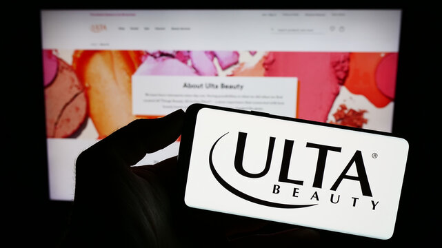 Stuttgart, Germany - 08-11-2023: Person holding cellphone with logo of American cosmetics retail company Ulta Beauty Inc. on screen in front of webpage. Focus on phone display.