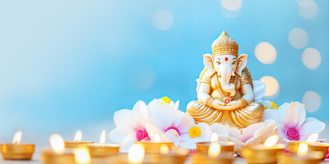 Holiday of Ganesh Chaturthi banner. Sculpture of ganesha with flowers and candles on blue background with copy space. Lord Ganesha, Ganesh festival. Hindu religion holiday - obrazy, fototapety, plakaty