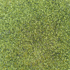 Green focused glitter texture as background