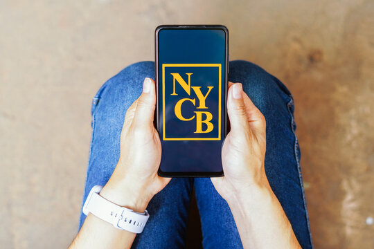 August 16, 2023, Brazil. In this photo illustration, the New York Community Bank (NYCB) logo seen displayed on a smartphone.