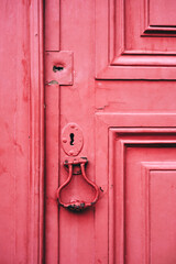 Detail of a red wooden church door of Alfama, Lisbon.