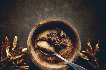 Brown sugar and star anise in a wooden bowl. Christmas baking ingredients