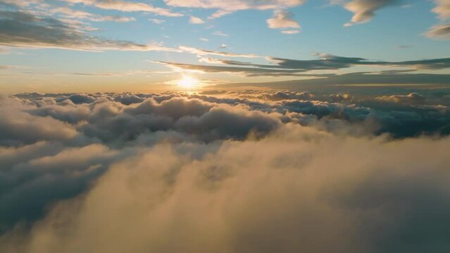 Flight above the clouds towards the sun. Misty weather, view from above. Birds point of view. Aerial camera shot.