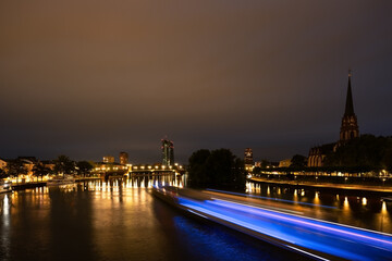 Obraz premium Frankfurt river Main in the evening. Blured ship in the foreground and a church on the right.